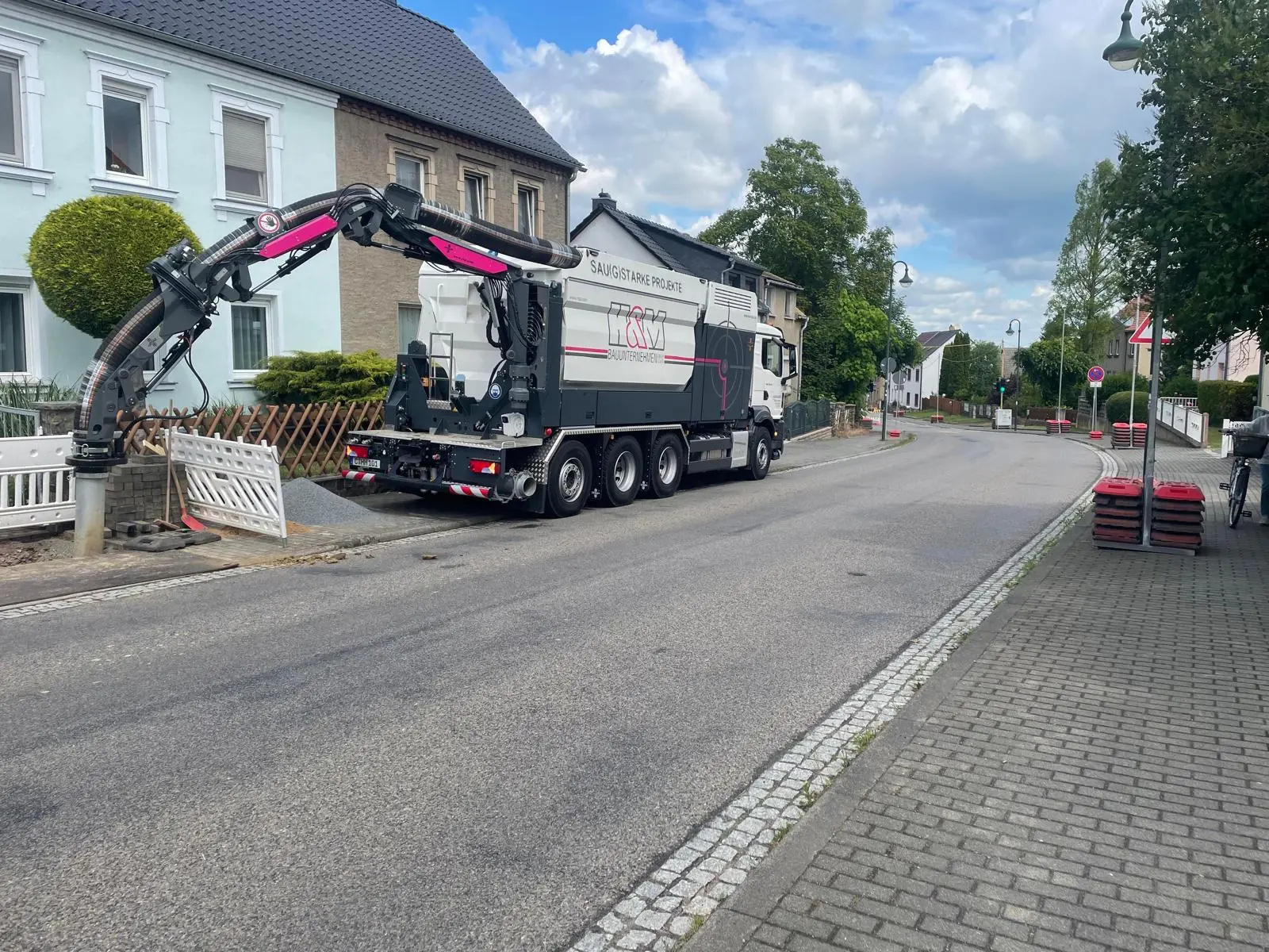 Firmeneigener Saugbagger von H & M bei einem Einsatz im Wohngebiet
